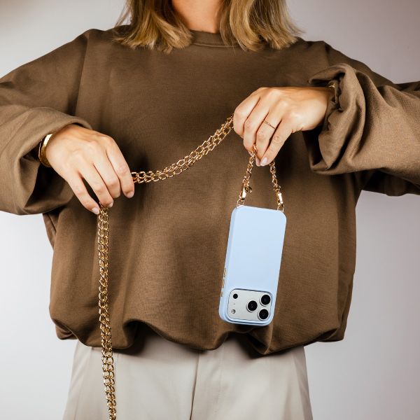 Selencia Rivièra MagSafe Backcover mit abnehmbaren Haken für das Apple iPhone 17 Pro - Powder Blue + Bold Chain (130 cm) - Gold