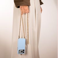Selencia Rivièra MagSafe Backcover mit abnehmbaren Haken für das Apple iPhone 15 - Powder Blue + Bold Chain (130 cm) - Gold